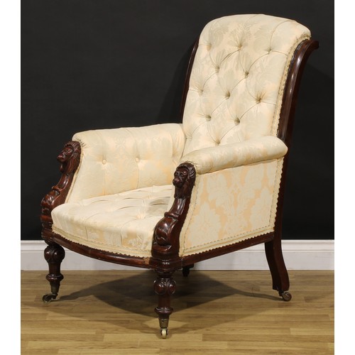 1353 - A Victorian mahogany library chair, stuffed-over deep-button upholstery, the hand rests carved as li... 