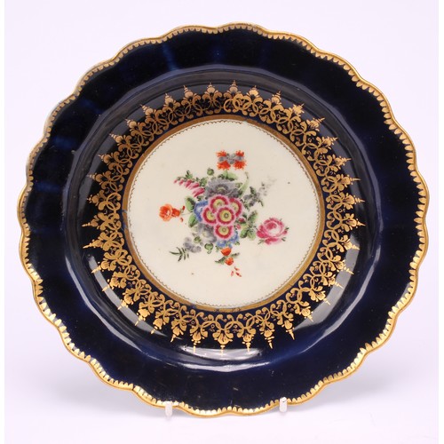 56 - A near pair of Worcester lobed dessert plates, painted with a vignette of colourful flowers within s... 