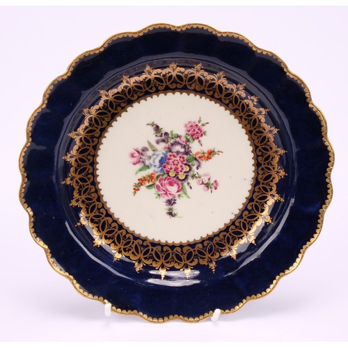 56 - A near pair of Worcester lobed dessert plates, painted with a vignette of colourful flowers within s... 