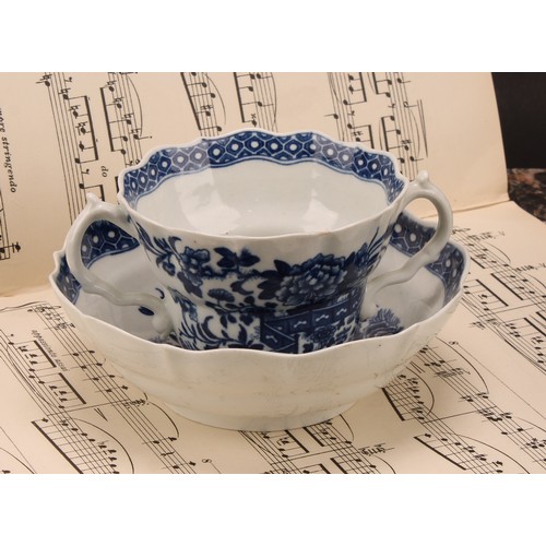 78 - A Worcester Fence pattern ogee shaped chocolate cup and saucer, in underglaze blue, cell border, ser... 