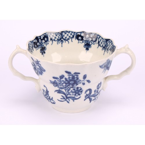 90 - A Worcester Three Flowers pattern ogee shaped chocolate cup and saucer, in underglaze blue, serpent ... 