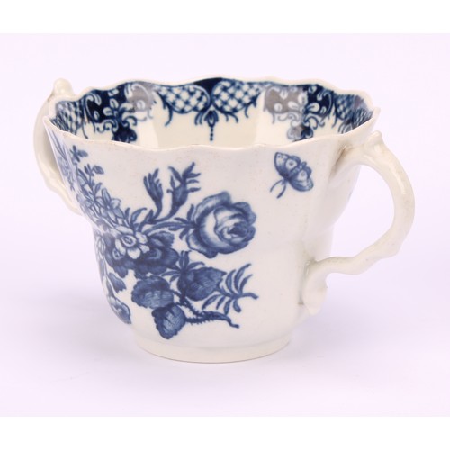 90 - A Worcester Three Flowers pattern ogee shaped chocolate cup and saucer, in underglaze blue, serpent ... 