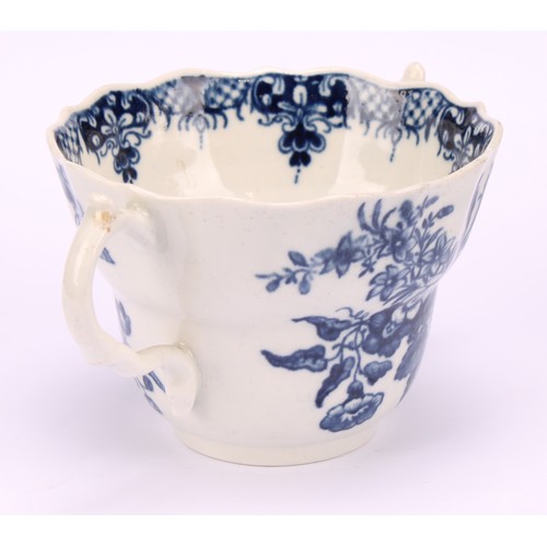 90 - A Worcester Three Flowers pattern ogee shaped chocolate cup and saucer, in underglaze blue, serpent ... 