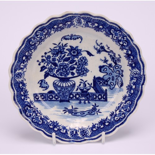 76 - A Worcester Bat pattern scalloped napkin dish, decorated in underglaze blue with a chinoiserie garde... 