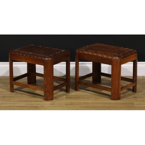 1545 - A pair of Art Deco period teak low tables, each carved with a border of flowers and foliage, 34cm hi... 