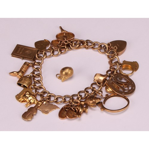 930 - A 9ct gold charm bracelet, the links and love heart clasp stamped '375' and '9ct', assorted 9ct gold... 