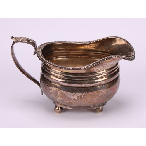 669 - A George V silver three piece boat shaped tea service, comprising teapot, sugar basin and cream jug,... 