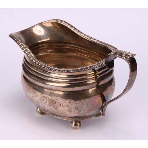 669 - A George V silver three piece boat shaped tea service, comprising teapot, sugar basin and cream jug,... 