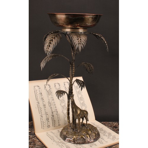 548 - A late 19th century E.P.N.S. table centrepiece, modelled with a giraffe standing beneath palm trees,... 