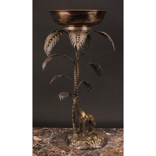 548 - A late 19th century E.P.N.S. table centrepiece, modelled with a giraffe standing beneath palm trees,... 