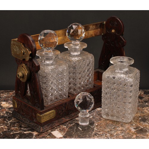 1899 - A Victorian oak three bottle tantalus, Betjemann's Patent London, 'The Tantalus', the mobile brass c... 