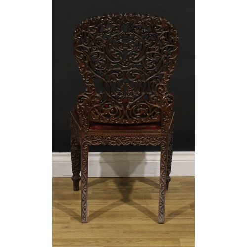 1320 - A 19th century Burmese hardwood side chair, pierced and profusely carved with scrolls, 87cm high, 47... 