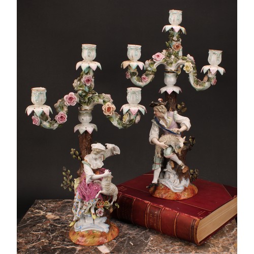 141 - A pair of 19th century German porcelain figural four-light, three-branch candelabra, as a shepherd a... 