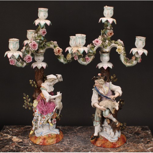 141 - A pair of 19th century German porcelain figural four-light, three-branch candelabra, as a shepherd a... 