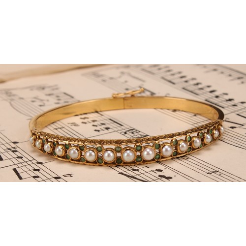 957 - An 18ct gold hinged bangle, set with 15 graduated pearls, each flanked and divided by pairs of small... 