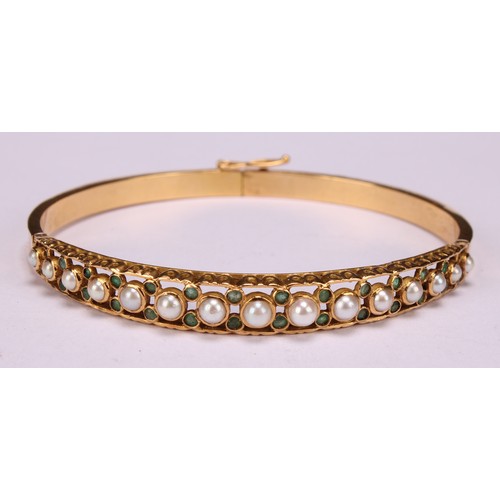 957 - An 18ct gold hinged bangle, set with 15 graduated pearls, each flanked and divided by pairs of small... 