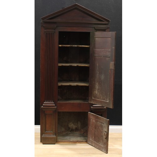 1389 - A 19th century mahogany architectural corner cabinet, pointed-arch pediment above two raised and fie... 