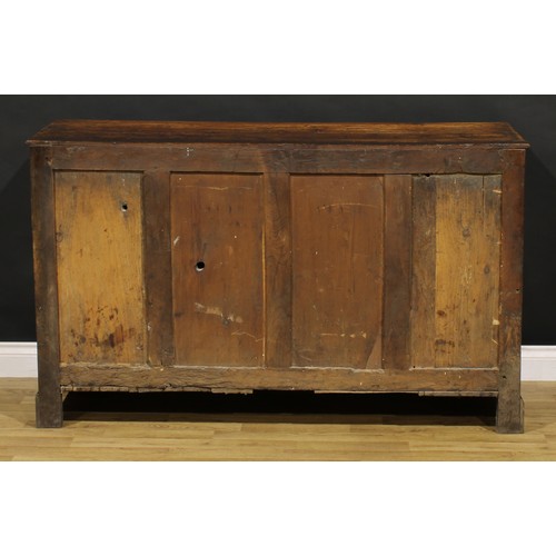 1194 - A George III oak low dresser, rectangular top above an arrangement of drawers and a pair of panel do... 