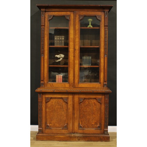 1336 - A late Victorian Aesthetic Movement period oak library bookcase, outswept cornice above a pair of gl... 