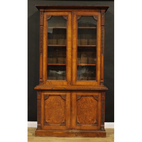 1336 - A late Victorian Aesthetic Movement period oak library bookcase, outswept cornice above a pair of gl... 