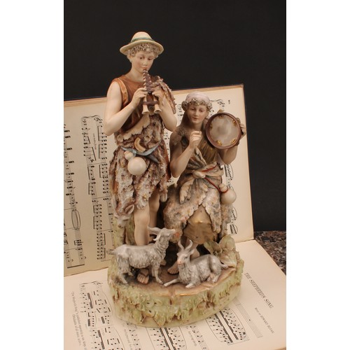 154 - A Royal Dux figure group, modelled with shepherd and shepherdess musicians, he with pipes, her seate... 