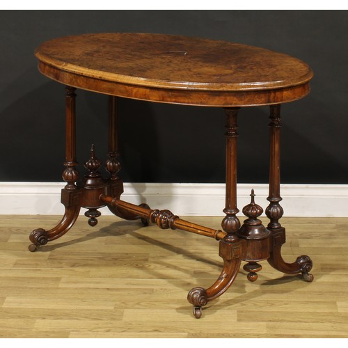 1448 - A Victorian walnut oval centre table, moulded top with matched veneers, turned and fluted supports a... 