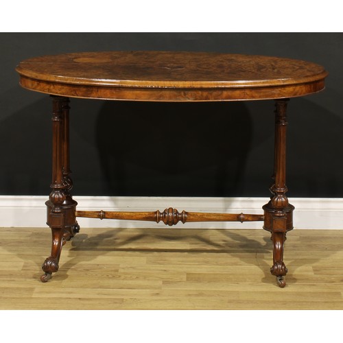 1448 - A Victorian walnut oval centre table, moulded top with matched veneers, turned and fluted supports a... 