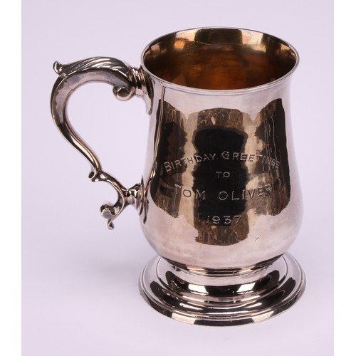 631 - A George III silver bell shaped mug, acanthus-capped double scroll handle, skirted base, presentatio... 