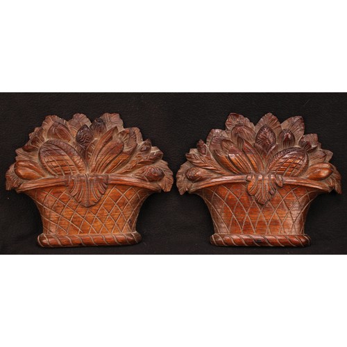 1291 - A pair of 19th century oak wall bosses or appliques, carved as baskets of fruit, 30cm wide