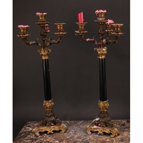 1289 - A pair of 19th century gilt and dark patinated bronze, and black marble four-light table candelabra,... 