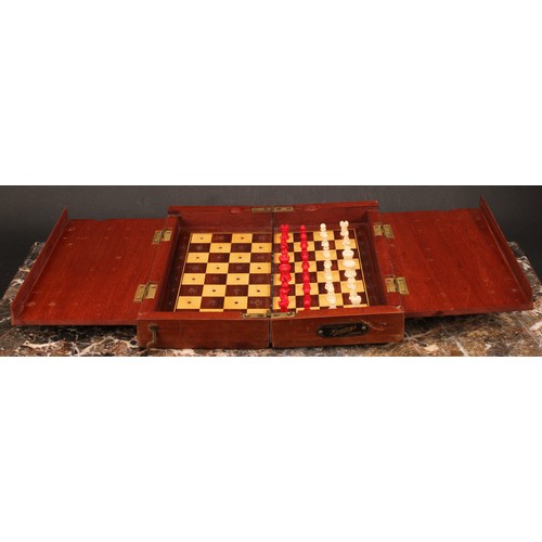 1917 - An early 20th century mahogany travelling chess set, by Hamleys, London, turned bone pieces with red... 