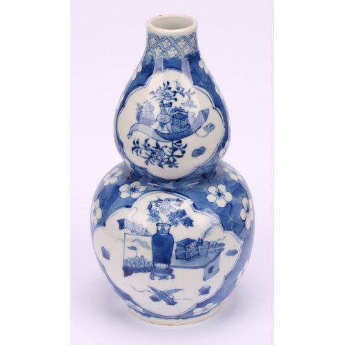 208 - A Chinese double gourd vase, painted in tones of underglaze blue with a scholar's table and precious... 