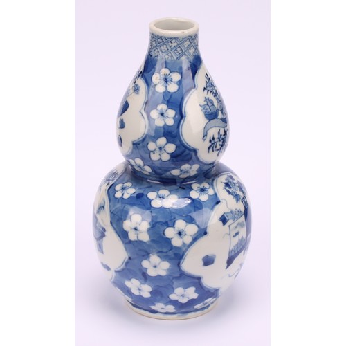 208 - A Chinese double gourd vase, painted in tones of underglaze blue with a scholar's table and precious... 