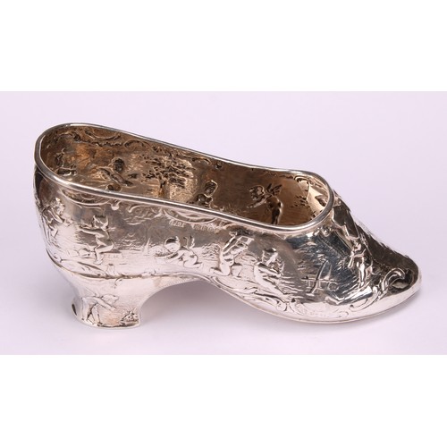 613 - A Dutch silver novelty vessel, as a shoe, chased with putti, 12cm long, import marks for London 1903... 