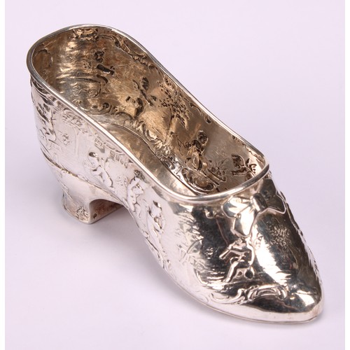 613 - A Dutch silver novelty vessel, as a shoe, chased with putti, 12cm long, import marks for London 1903... 