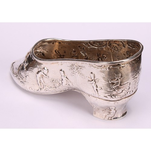 613 - A Dutch silver novelty vessel, as a shoe, chased with putti, 12cm long, import marks for London 1903... 