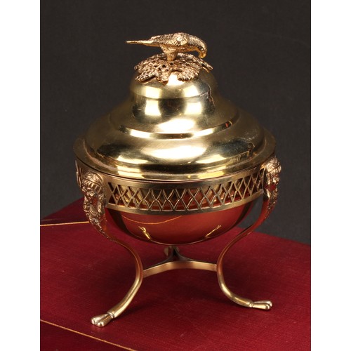 579 - A 19th century Continental silver-gilt sweetmeat box, the ogee cover crested by a parrot, the tripod... 