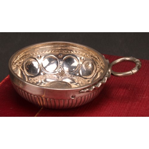 585 - A 19th century French silver wine taster, the chased and fluted bowl set with a Spanish coin, serpen... 