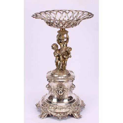 558 - A sculptural Victorian parcel-gilt E.P.N.S table centrepiece, central sweetmeat basket above three f... 