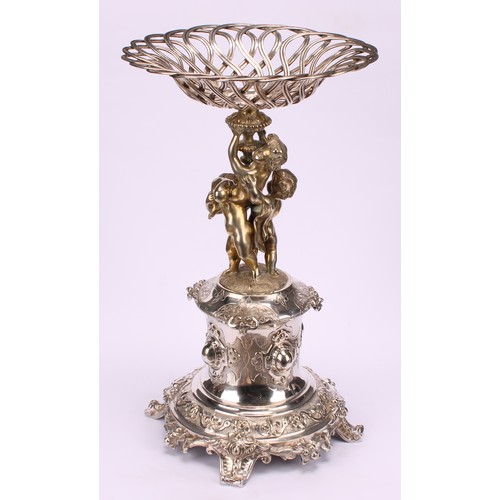 558 - A sculptural Victorian parcel-gilt E.P.N.S table centrepiece, central sweetmeat basket above three f... 