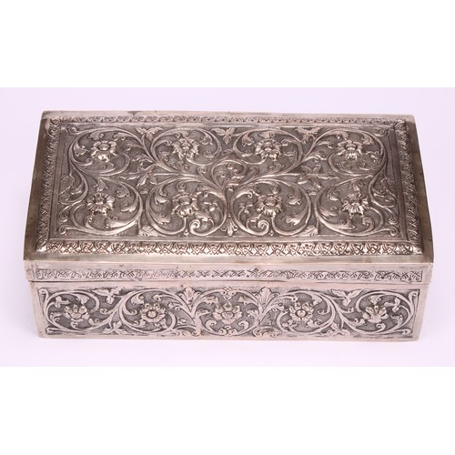 588 - A 19th century Indian silver rectangular box, chased with flowers and scrolling foliage, on a matted... 