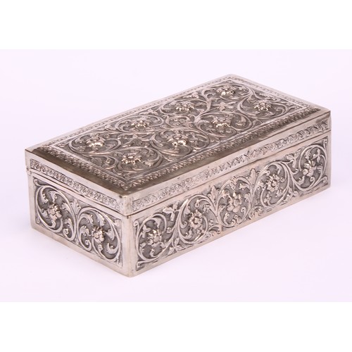 588 - A 19th century Indian silver rectangular box, chased with flowers and scrolling foliage, on a matted... 