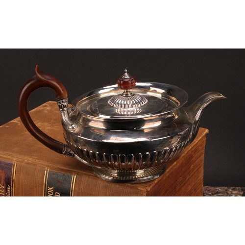 654 - A George IV silver half-fluted lamp shaped teapot, in the Regency taste, flush-hinged cover, scroll-... 