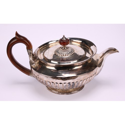 654 - A George IV silver half-fluted lamp shaped teapot, in the Regency taste, flush-hinged cover, scroll-... 