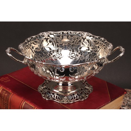 668 - A George V silver table centre fruit basket, of substantial gauge, pierced with scrolling vine, shap... 