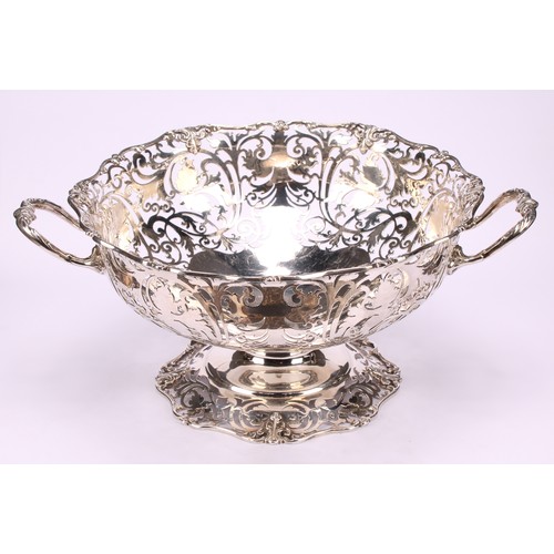 668 - A George V silver table centre fruit basket, of substantial gauge, pierced with scrolling vine, shap... 