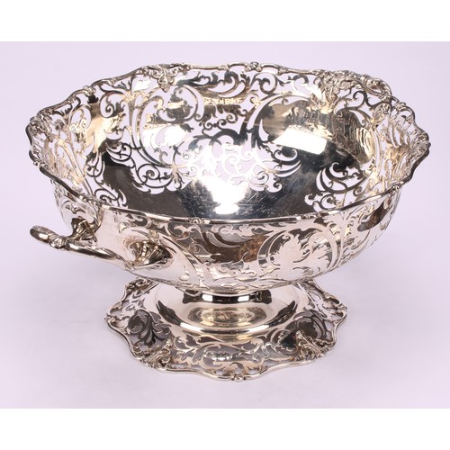 668 - A George V silver table centre fruit basket, of substantial gauge, pierced with scrolling vine, shap... 