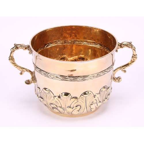 678 - A James II silver-gilt porringer, chased with a laurel girdle and a band of acanthus, 14cm over grot... 