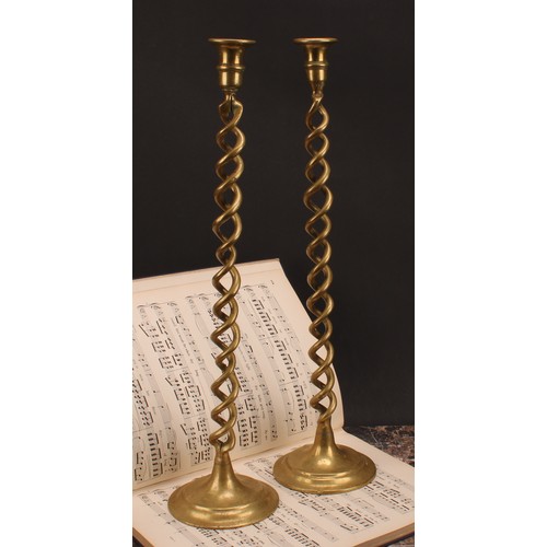 1250 - A pair of tall late Victorian brass open-twist candlesticks, campana sconces, domed bases, 52cm high... 