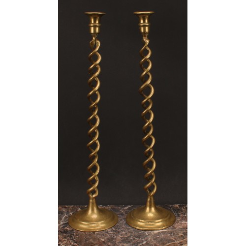 1250 - A pair of tall late Victorian brass open-twist candlesticks, campana sconces, domed bases, 52cm high... 